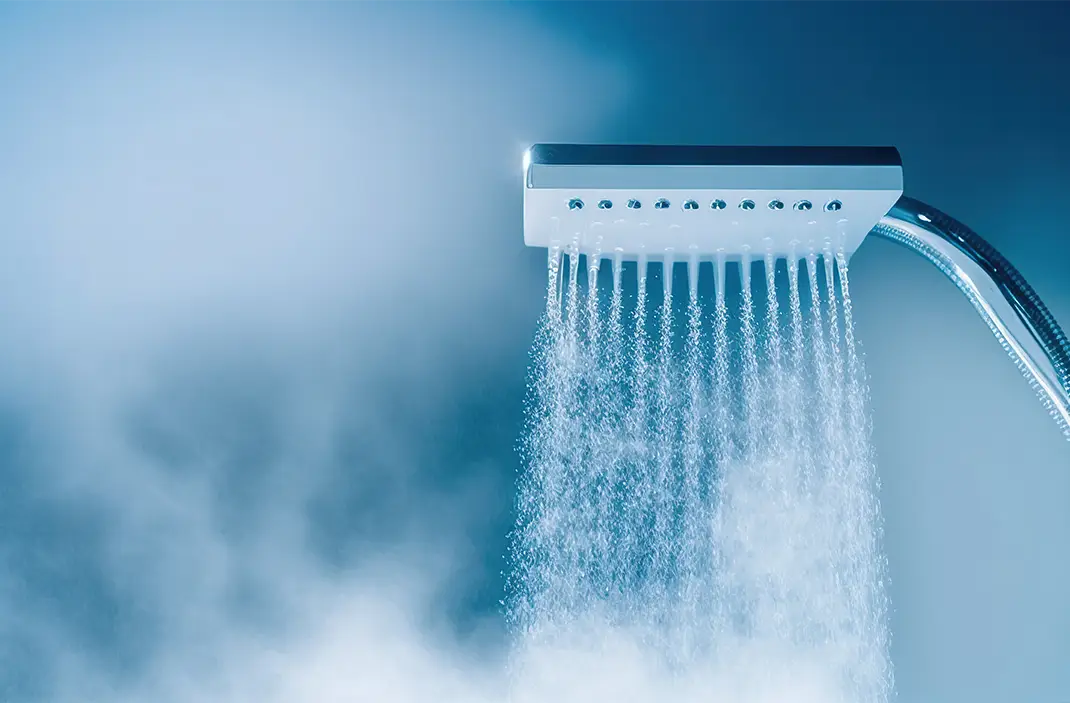 Frisk dusch bakom vått glasfönster med stänkande vattendroppar.